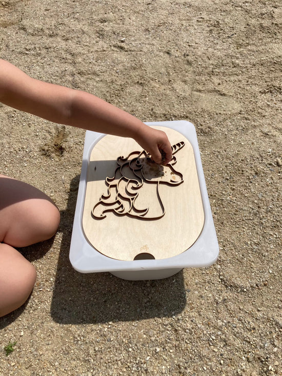 Activité Montessori avec une planche en bois licorne, idéale pour le transvasement et la motricité fine.