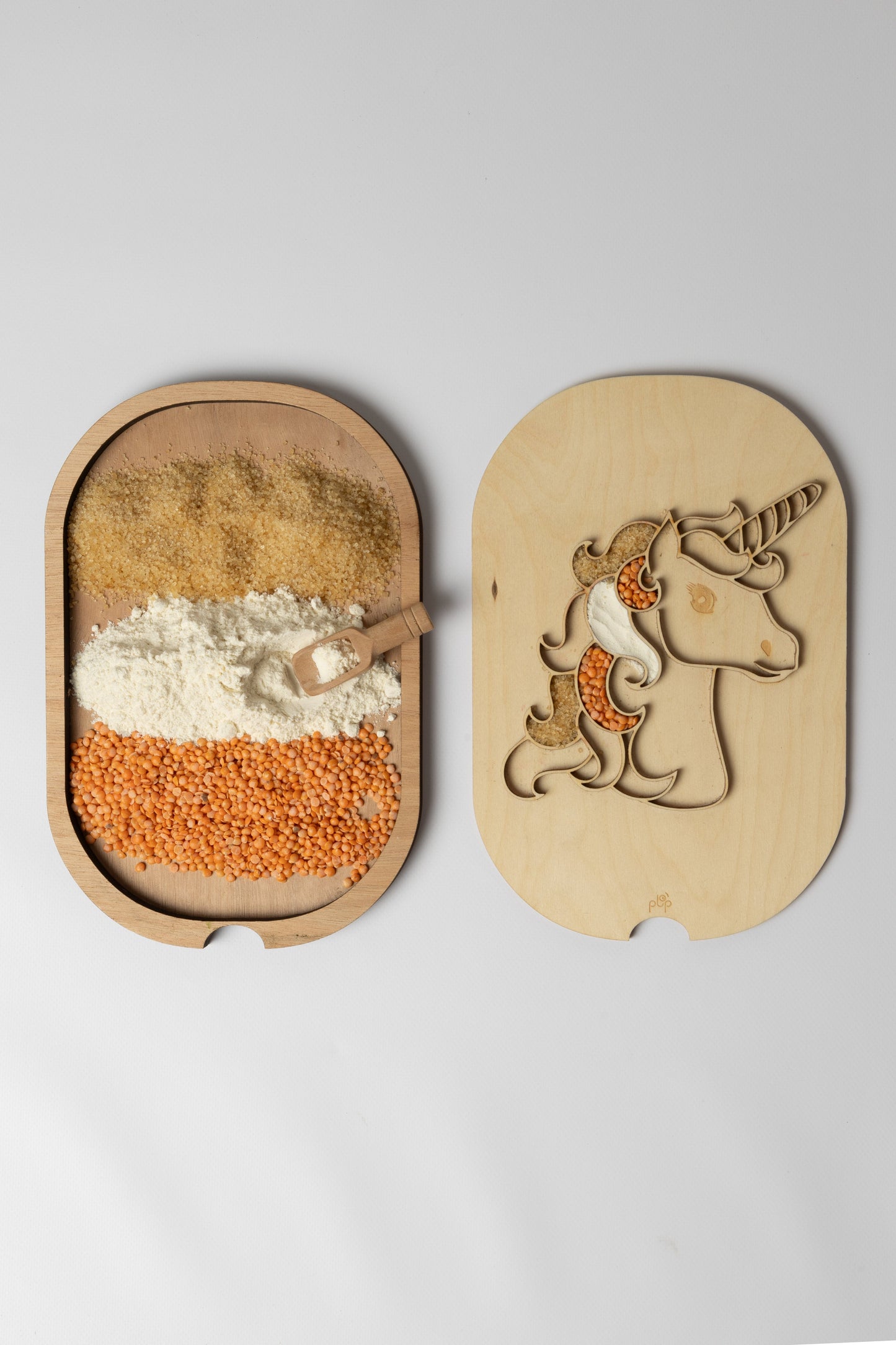 Planche licorne Montessori avec compartiments remplis d’ingrédients pour une activité sensorielle amusante.