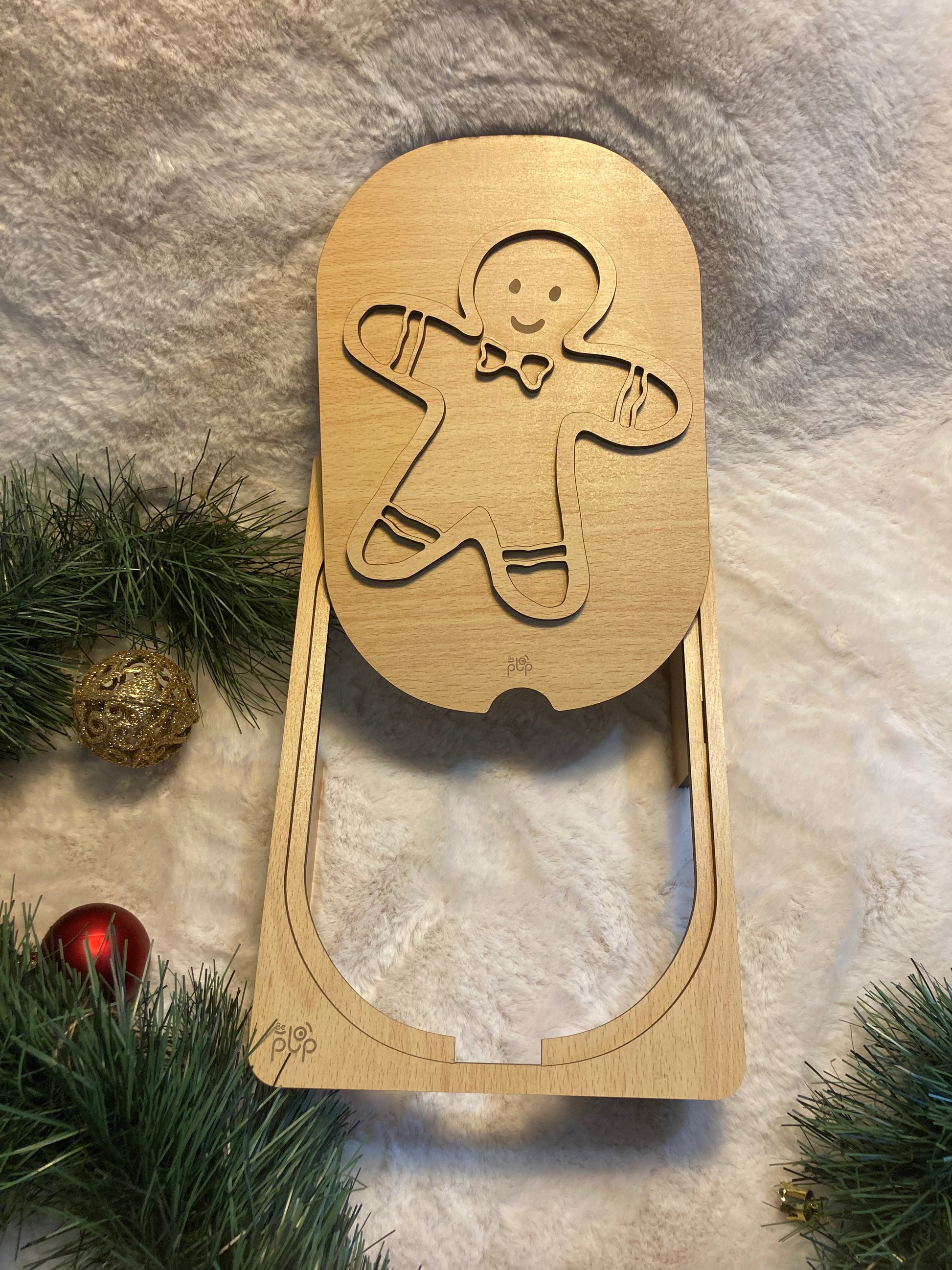 Planche Montessori en bois avec un motif de bonhomme en pain d’épices, montée sur un support en bois naturel, décorée dans un thème de Noël.